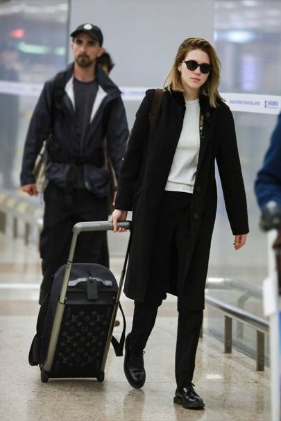 Léa Seydoux pairs her carry-on with a Nineties minimalist stance.